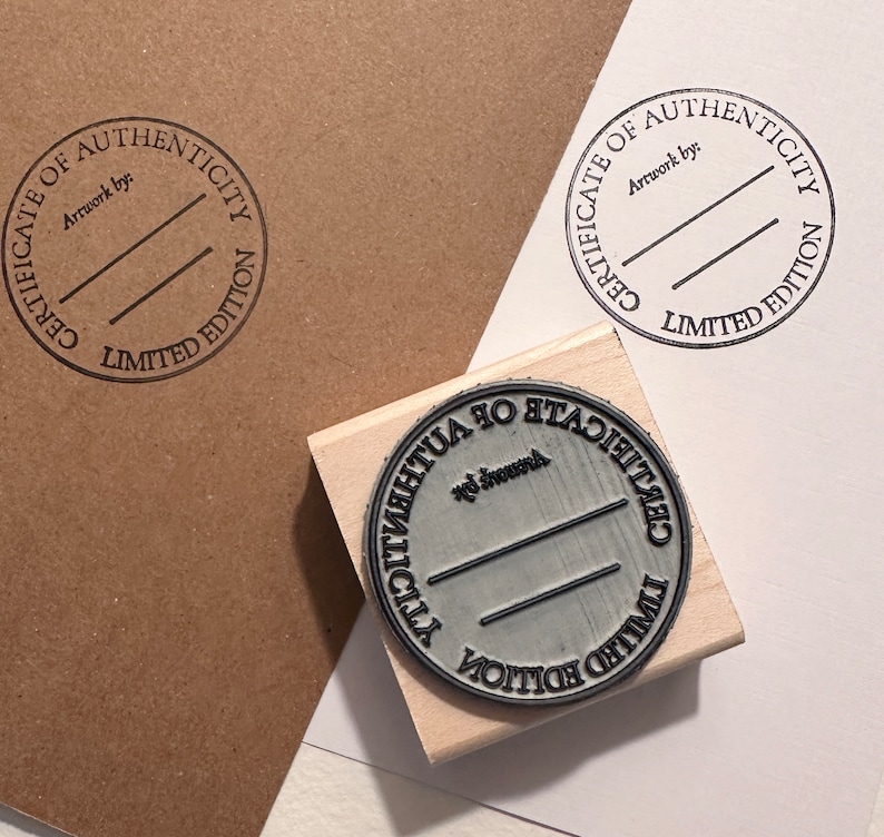 May include: Two wooden stamps with a circular design. The stamps read "Certificate of Authenticity Limited Edition" and include a line for "Artwork by:".