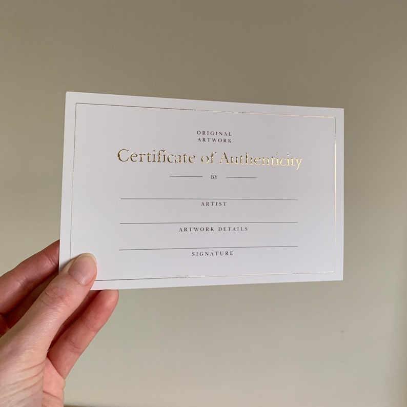 May include: A white certificate of authenticity with gold lettering. The certificate has spaces for the artist's name, artwork details, and signature.