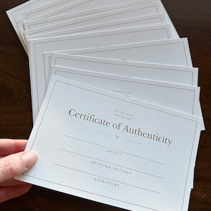 Stack of gold foil Certificate of Authenticity cards