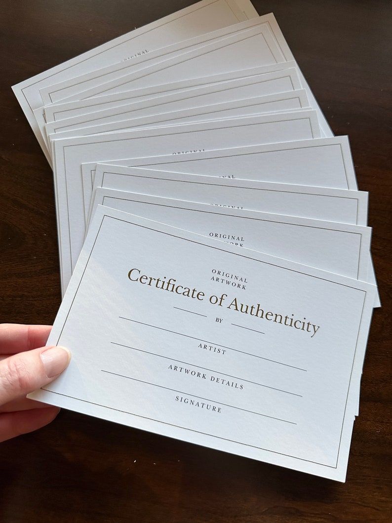 Stack of gold foil Certificate of Authenticity cards
