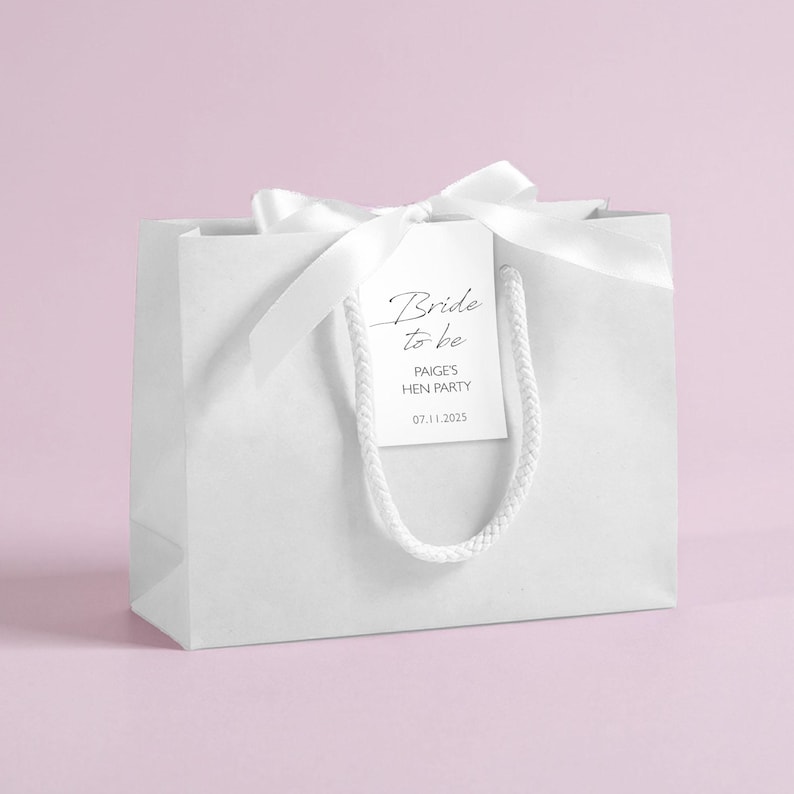 Personalised hen party gift bags with custom tags and ribbons, perfect for adding a special touch to hen do favours. Made from 100% recycled paper with reinforced bases and soft rope handles, these elegant bags can be customised with names, dates, or messages. Ideal for presenting gifts or party favours in style.