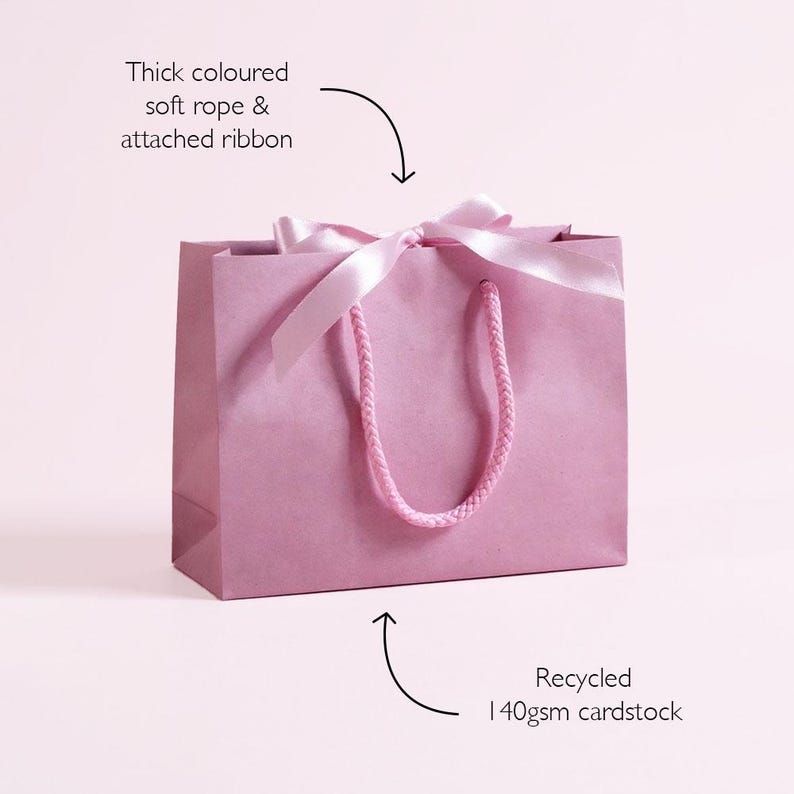 Personalised hen party gift bags with custom tags and ribbons, perfect for adding a special touch to hen do favours. Made from 100% recycled paper with reinforced bases and soft rope handles, these elegant bags can be customised with names, dates, or messages. Ideal for presenting gifts or party favours in style.