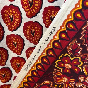 May include: Close-up of two fabric swatches. One features a repeating pattern of red, yellow, and black teardrop shapes on a cream background. The other displays a floral design with the text "VERITABLE JAVA HOLLANDAIS" along the edge.