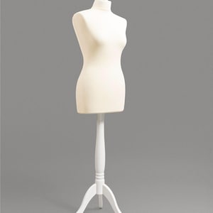 Op de afbeelding: Een crèmekleurige paspop op een witte houten standaard. De paspop heeft een afgeronde bovenkant en een slanke taille, en de standaard heeft drie poten. De paspop is ontworpen voor het presenteren van kleding.
