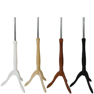 Puede incluir: Cuatro soportes de trípode para exhibir ropa. Los soportes están hechos de madera con un acabado blanco, madera natural, marrón y negro.