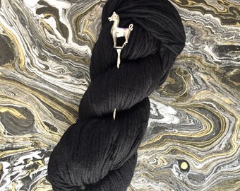 May include: A skein of black yarn with a silver llama yarn needle.