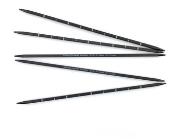 May include: Five black knitting needles with white markings. The needles are 6 inches long and are size US 5/3.75 mm. The text "Kollage Square Needles US5/3.75mm 6" (15 cm)" is printed on two of the needles.