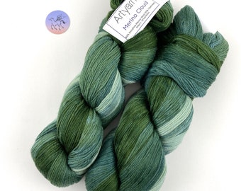 Puede incluir: Dos ovillos de hilo verde y azul jaspeado etiquetados "Artyarns Merino Cloud 100% Extra Fine Merino Wool 20% Cashmere 50g/1.75oz 437 yards/399m"