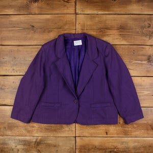 May include: A purple blazer with a single button fastening and two pockets. The blazer is made from a textured fabric.