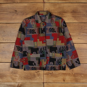 May include: A multi-coloured patterned jacket with a button closure. The jacket has a patchwork design with geometric shapes and leaf motifs in shades of red, blue, green, yellow, and black.