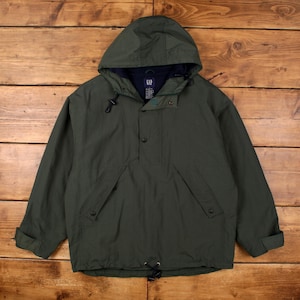 May include: A dark olive green pullover jacket with a hood, featuring a navy blue interior lining, a partial button-up front placket, two slanted front pockets with button closures, and a drawstring hem. The label inside the neck reads GAP.