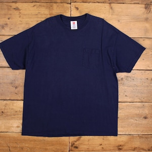 Peut inclure: T-shirt bleu marine avec une poche poitrine. Le t-shirt a un col rond et des manches courtes. Une petite étiquette blanche est visible à l'intérieur du col. Le t-shirt est en matière douce et confortable.