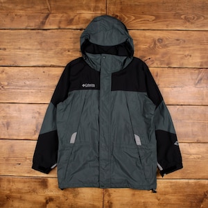 Könnte beinhalten: Eine grüne und schwarze Kapuzenjacke mit Reißverschluss und dem Columbia-Logo auf der linken Brust. Die Jacke hat eine Kapuze mit Kordelzug und zwei Reißverschlusstaschen.