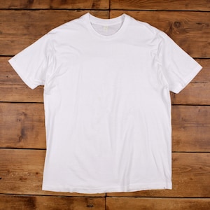 Könnte beinhalten: Ein schlichtes, weißes T-Shirt mit kurzen Ärmeln und einem Rundhalsausschnitt. Das Kleidungsstück zeichnet sich durch ein einfaches, einfarbiges Design mit Standardpassform, kurzen Ärmeln und einem runden Kragen aus, ohne Muster oder Aufdrucke.