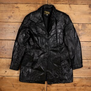 Puede incluir: Chaqueta de cuero negro con cuello clásico y cierre de botones. La chaqueta presenta un diseño de patchwork y un corte entallado. La chaqueta tiene una etiqueta que dice "Leather Soul Genuine Leather".