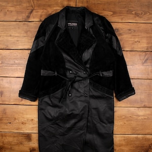 Può includere: Un cappotto nero vintage con design doppiopetto. Il cappotto presenta un mix di texture, tra cui pannelli in pelle e velluto, e una cintura abbinata. L'etichetta "Wilsons The Leather Experts" è visibile all'interno.