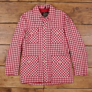May include: Red and white checkered jacket with four front pockets and button closures. The jacket has a collared neckline and long sleeves. The interior lining is red. The jacket is made of a woven fabric.