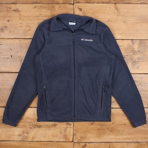 Puede incluir: Una chaqueta de forro polar azul oscuro con cierre de cremallera y un logotipo de Columbia en el pecho.