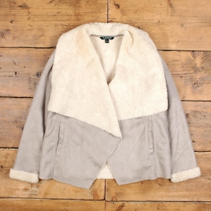 May include: A light grey jacket with a cream-coloured, fluffy collar and lining. The jacket has a draped front and rolled cuffs. The brand "LAUREN" is visible on the label. The jacket is made of a soft, suede-like material.
