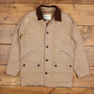 Könnte beinhalten: Beige Orvis Jacke mit braunem Cordkragen, vier Knöpfen vorne und zwei großen Vordertaschen. Die Jacke hat ein klassisches, zweckmäßiges Design.