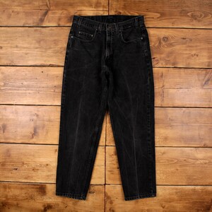 Peut inclure: Un pantalon en jean noir avec un aspect délavé. Le jean a une conception classique à cinq poches, une fermeture à bouton et à glissière, et une coupe droite. Le tissu semble pré-lavé pour un look usé.
