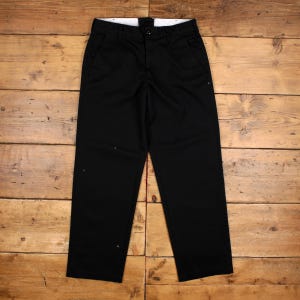 May include: A pair of solid black trousers featuring a straight-leg cut, a central button closure, a zip fly, and two side pockets. The garment has a structured waistband with belt loops and a clean, minimalist design with no visible patterns.