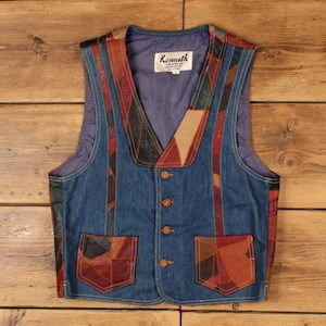 Könnte beinhalten: Eine ärmellose Weste mit einer blauen Jeans-Basis und Patchwork-Lederakzenten in Braun-, Rot- und Schwarztönen. Das Kleidungsstück hat einen V-Ausschnitt, vier braune Knöpfe, zwei Vordertaschen und ein Etikett mit der Aufschrift Kenneth, Größe L.