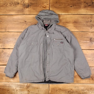 May include: A grey hooded jacket featuring a full-length zip and a snap-button placket. The garment includes two chest pockets with flaps, a small zipped pocket above the left chest pocket, and a Dickies brand label on the left pocket.