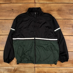 May include: Black, green, and white track jacket with a full-length zipper. The jacket has a high collar and white stripes on the sleeves and chest. The bottom half of the jacket is green.