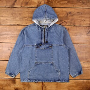 May include: A light blue denim hooded jacket with a half-zip closure and a front pocket. The jacket has a drawstring at the hood and a white lining. The jacket is made of a sturdy denim material.