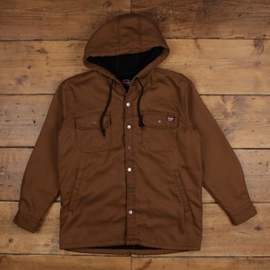 May include: A brown hooded jacket featuring a front button closure with silver-toned metal buttons, two chest pockets with button flaps, two side pockets, and a black interior lining. The garment includes a drawstring hood and a Wrangler brand label.