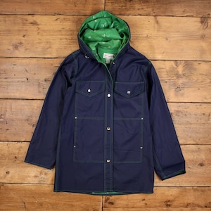 May include: A navy blue hooded jacket with green stitching and a green interior lining. The jacket has two chest pockets and two lower pockets. The hood lining features a white anchor pattern. The jacket is fastened with buttons.
