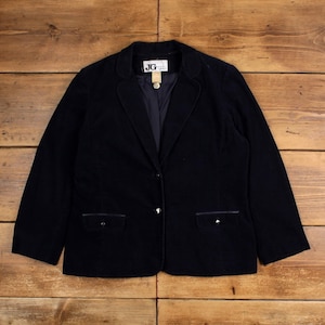Op de afbeelding: Een donker marineblauwe corduroy blazer met een gekerfde revers, twee voorzakken en een sluiting met één knoop. De blazer heeft een klassiek ontwerp en een getailleerde pasvorm. Het label luidt "JG".