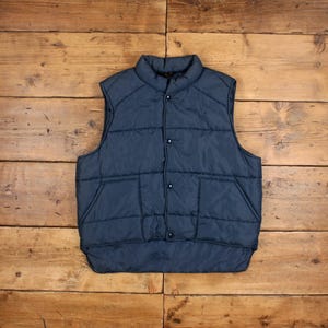 May include: A dark blue quilted vest with a snap closure and two front pockets.
