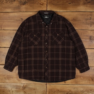 Peut inclure: Une chemise à manches longues boutonnée marron foncé avec un motif à carreaux fins beige. La chemise présente deux poches de poitrine à rabat, un col pointu et une doublure intérieure matelassée noire visible au col et à l'ourlet.