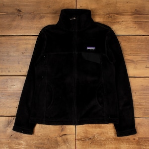 以下が含まれることがあります： ハイネックとフルレングスのジッパーが付いた黒いフリースジャケット。 ジャケットには、2つのフロントポケットと胸に小さなロゴパッチが付いています。 ジャケットは柔らかく、豪華な素材で作られています。