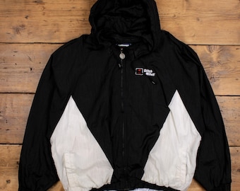 Puede incluir: Chaqueta cortavientos negra y blanca con una cremallera negra y un logotipo rojo y blanco que dice "Pitch Witch".