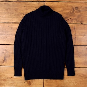 May include: A navy blue turtleneck jumper with a ribbed knit pattern. The jumper features long sleeves and a high, folded collar. The garment is made of a thick, warm material, suitable for colder weather.