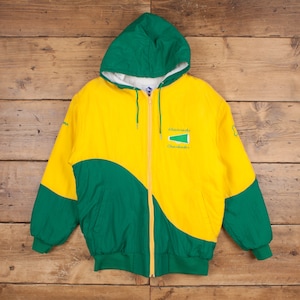 May include: A yellow and green hooded jacket with a zip closure. The jacket has a large green and yellow graphic on the front with the text "Shamrocks Cheerleaders".