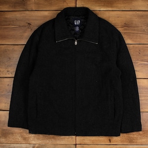 May include: A black Gap jacket with a full zip and quilted lining. The jacket features a collar and two front pockets. The Gap logo is visible inside the collar. The jacket is made of a textured fabric.