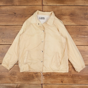 May include: A cream-colored jacket with a snap closure and a drawstring at the bottom. The jacket has a label that reads "Snowy Mountain".