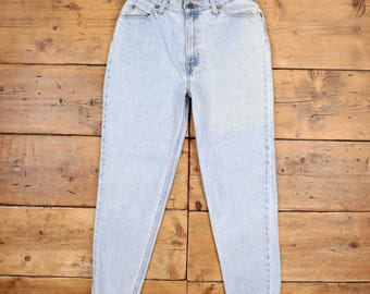 May include: Light wash denim jeans with a classic five-pocket design. The jeans have a high waist and a straight leg, with a button and zipper closure. The jeans are a light blue color and appear to be made of a durable denim material.