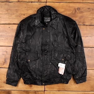May include: Black leather jacket with a collared neckline, two front pockets, and a ribbed hem. The jacket has a patchwork design and a tag that reads "GENUINE LEATHER".