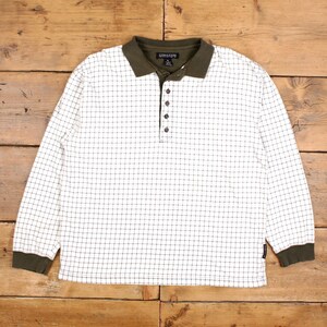May include: A long-sleeved polo shirt with a white grid pattern and a dark green collar and cuffs. The shirt has a button-up placket and a small logo near the hem. The shirt is made of a soft, comfortable material.
