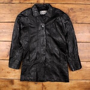 May include: Black leather jacket with a patchwork design. The jacket features a collared neckline, button-down closure, and long sleeves. The brand name "Cellini" is visible on the label.
