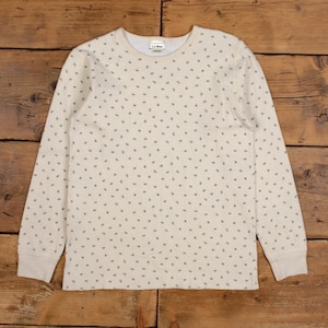 Peut inclure: T-shirt à manches longues de couleur crème avec un petit motif répété de formes vert foncé. Le t-shirt a un col rond et des poignets côtelés. L'étiquette de la marque "L.L.Bean" est visible au niveau de l'encolure. Le tissu est doux et confortable.