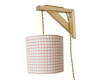 Lampe équerre avec un abat-jour en tissu à carreaux rose et doré