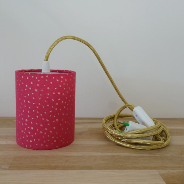 Lampe baladeuse nomade avec son tissu rose fushia à étoiles dorées sert de lampe de chevet