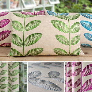 May include: Four decorative throw pillows with a beige background and a green, blue, or pink leaf design. The pillows are arranged in a row on a wooden surface.