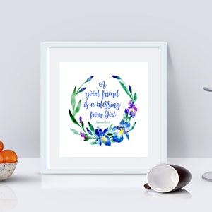 May include: A white framed print with a watercolor floral wreath in shades of blue, green, and purple. The wreath surrounds the text "A good friend is a blessing from God - 1 Samuel 18:1".